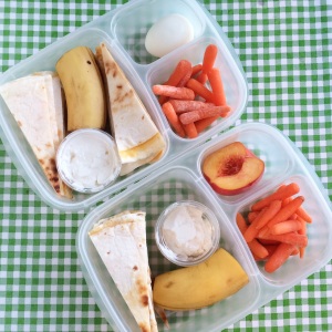 Quesadilla with sour cream for dipping, banana, carrots.  He has a boiled egg, she has a half a peach.